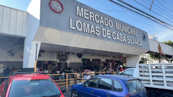 Mercado municipal con vehículos estacionados.